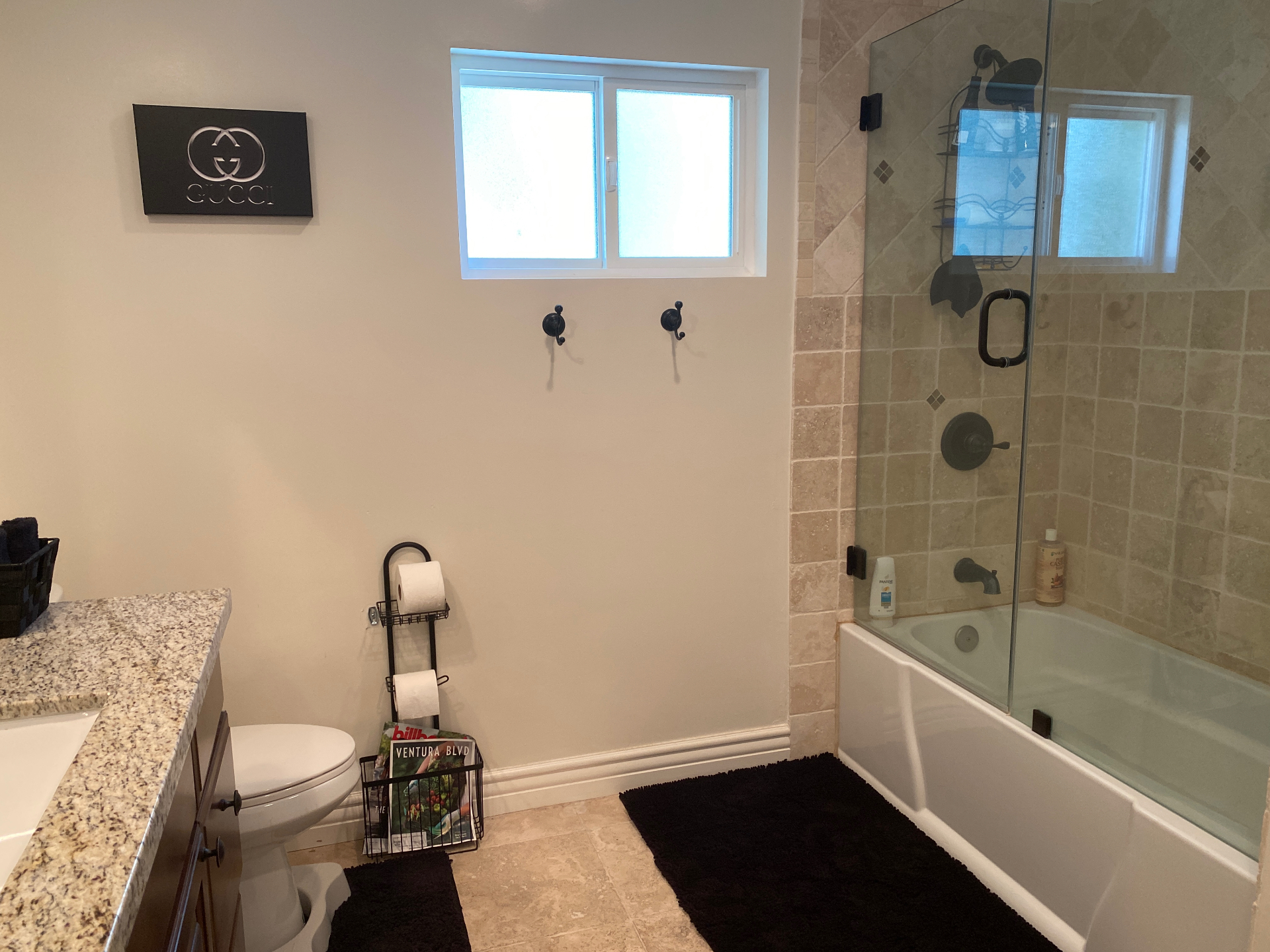 Dated bathroom with beige tile, tub, and framed mirrors before Venegas Construction remodel